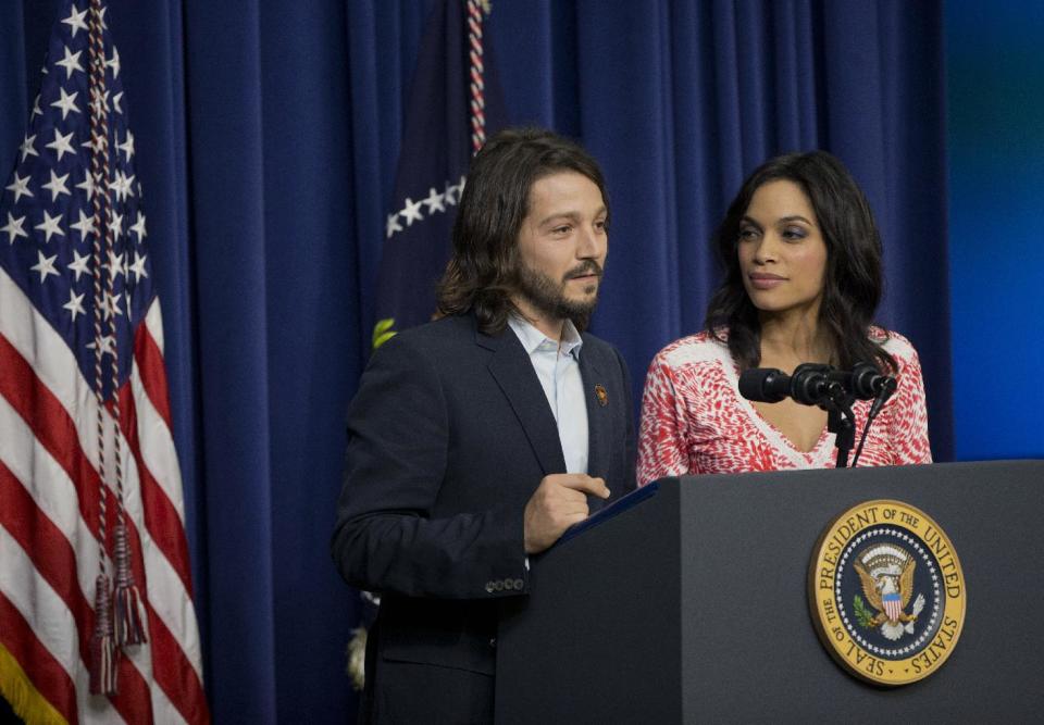 FILE - In this Wednesday, March 19, 2014 file photo, Diego Luna, left, and Rosario Dawson stand behind the podium after President Barack Obama spoke at the screening of the film "Cesar Chavez," in the Old Executive Office Building on the White House complex in Washington. Luna directed the movie biopic about the Mexican-American labor leader Chavez, that features Dawson as Dolores Huerta, the renowned civil rights activist. (AP Photo/Pablo Martinez Monsivais, file)