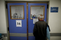 A man watches his wife who is suspected of having COVID-19 as she is attended at Llavallol Dr. Norberto Raúl Piacentini Hospital in Lomas de Zamora, Argentina, Saturday, May 1, 2021. The man's wife was intubated and a few days later passed away. (AP Photo/Natacha Pisarenko)