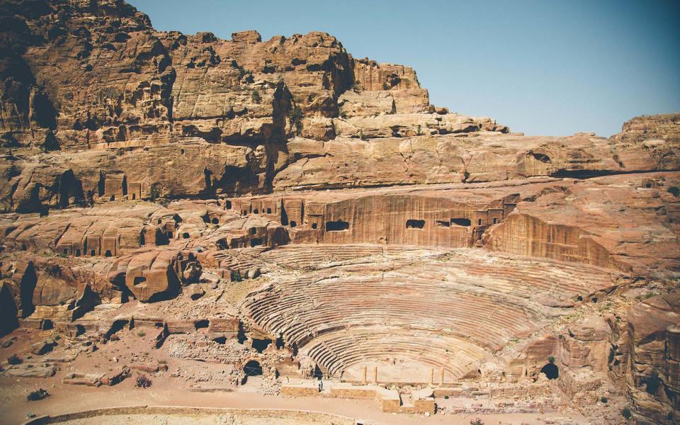 <p>I grab a barazek – a cookie made from butter, pistachios, and sugar – before I set off on day three of our hike. Scaling a tilted, flat mountain of stone, I trot skyward. Once at the top, I find an amphitheater where plateaus, peaks, and sediments merge; the onyx Sharah Mountains offer a poignant contradiction to a swath of sandstone. Before I descend into a basin of bulbous boulders, I see a former Ottoman Empire military base, now a mere heap of bricks: the perfect point to gaze at Wadi Araba below.</p>