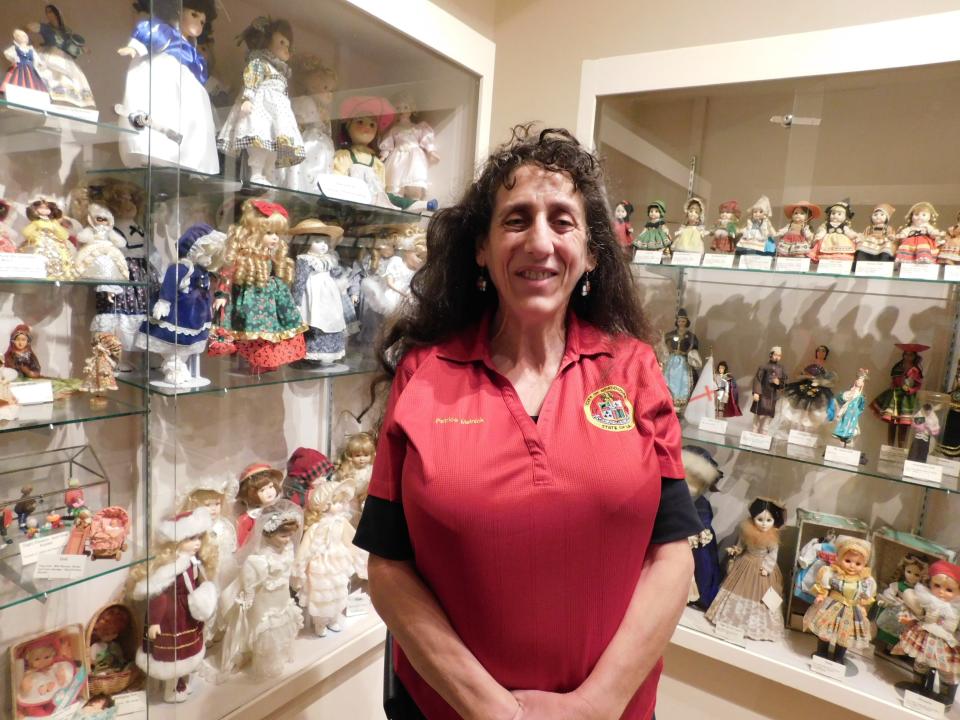 Museum director Patrice Melnick poses next to the Opelousas Museum and Interpretive Center's massive doll and doll house collection of Geraldine Welch Smith. While some of the estimated 400 dolls were purchased, Melnick said, Welch made several of them from Styrofoam cups and pipe cleaners.