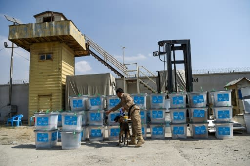 A sniffer dog checks election ballot boxes for explosives after they were unloaded from a truck at a warehouse in Kabul in September 2019