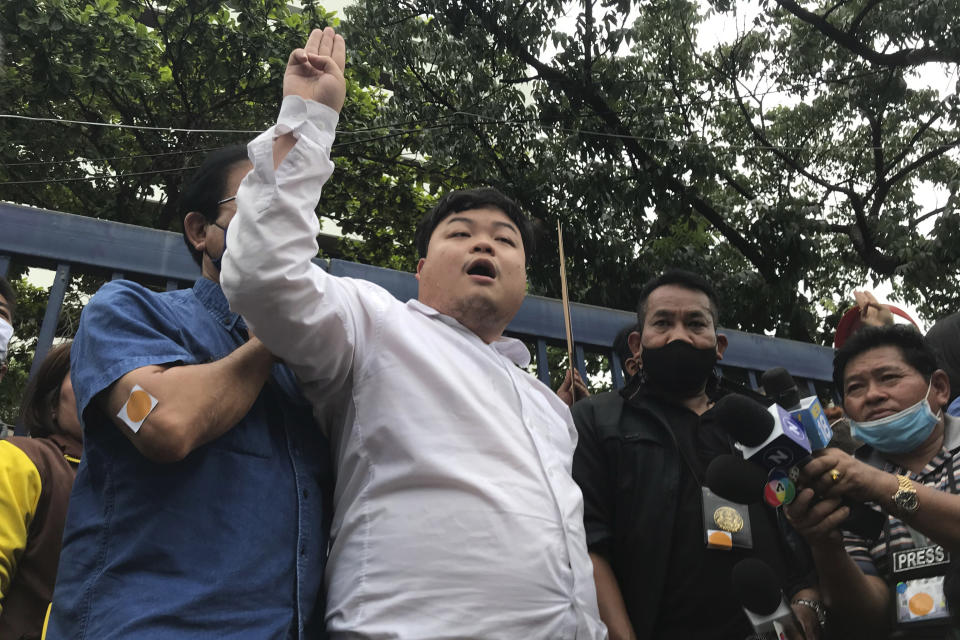 Protest leader Parit “Penguin” Chiwarak raises his hand with a three-fingered salute as a symbol of resistance outside the criminal court after he was released on bail Saturday, Aug. 15, 2020 in Bangkok, Thailand. Parit was arrested by police Friday on a sedition charge in connection with a July 18 protest. (AP Photo/Busaba Sivasomboon)