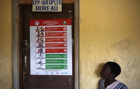 A student looks at a poster on Ebola prevention in a school at Gueupleu, Man, western Ivory Coast November 3, 2014. REUTERS/Thierry Gouegnon