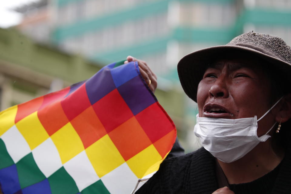A supporter of former President Evo Morales waves a "wiphala" flag that represents indigenous people, during a march of indigenous people entering La Paz, Bolivia, Tuesday, Nov. 12, 2019. Former President Evo Morales flew to exile in Mexico on Tuesday after weeks of violent protests, leaving behind a confused power vacuum in the Andean nation. (AP Photo/Natacha Pisarenko)