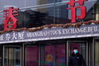 A security guard stands at the Shanghai Stock Exchange building at the Pudong financial district in Shanghai