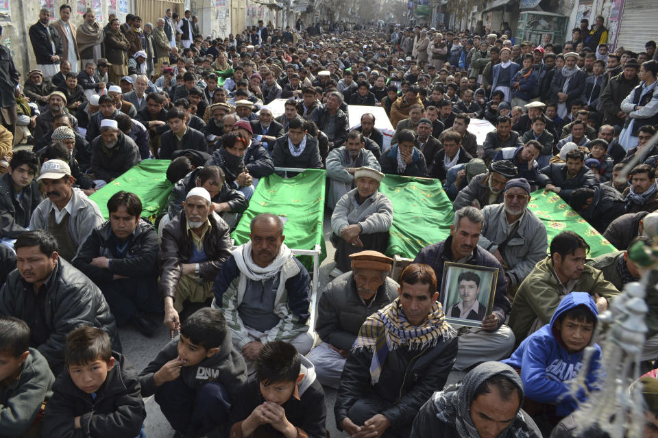 Relatives and mourners of Shiite pilgrims who were killed on Tuesday by a bomb blast, protest sitting next to their bodies, in Quetta, Pakistan, Wednesday, Jan. 22, 2014. Shiite Muslims in Baluchistan protested Wednesday in Quetta, the capital of Baluchistan, demanding action to stop the continued violence against their sect; they brought the coffins of many of the dead into the streets as part of their protest. (AP Photo/Arshad Butt)