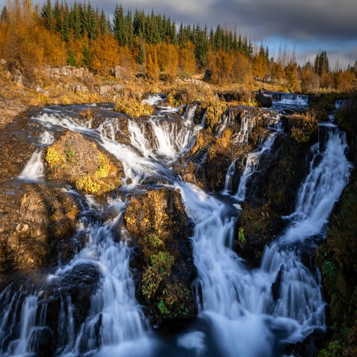 Kermoafoss waterfall surrounded by the forest in Reykjavik, Iceland