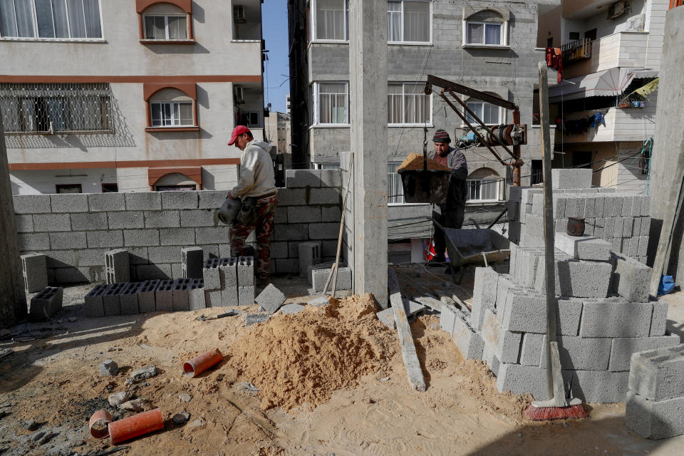 Palestinians build walls of a new apartment building in the central of al-Rimal neighborhood of Gaza City, Monday, Jan. 10, 2022. The Gaza Strip has few jobs, little electricity and almost no natural resources. But after four bruising wars with Israel in just over a decade, it has lots of rubble. Local businesses are now finding ways to cash in on the chunks of smashed concrete, bricks and debris left behind by years of conflict. (AP Photo/Adel Hana)