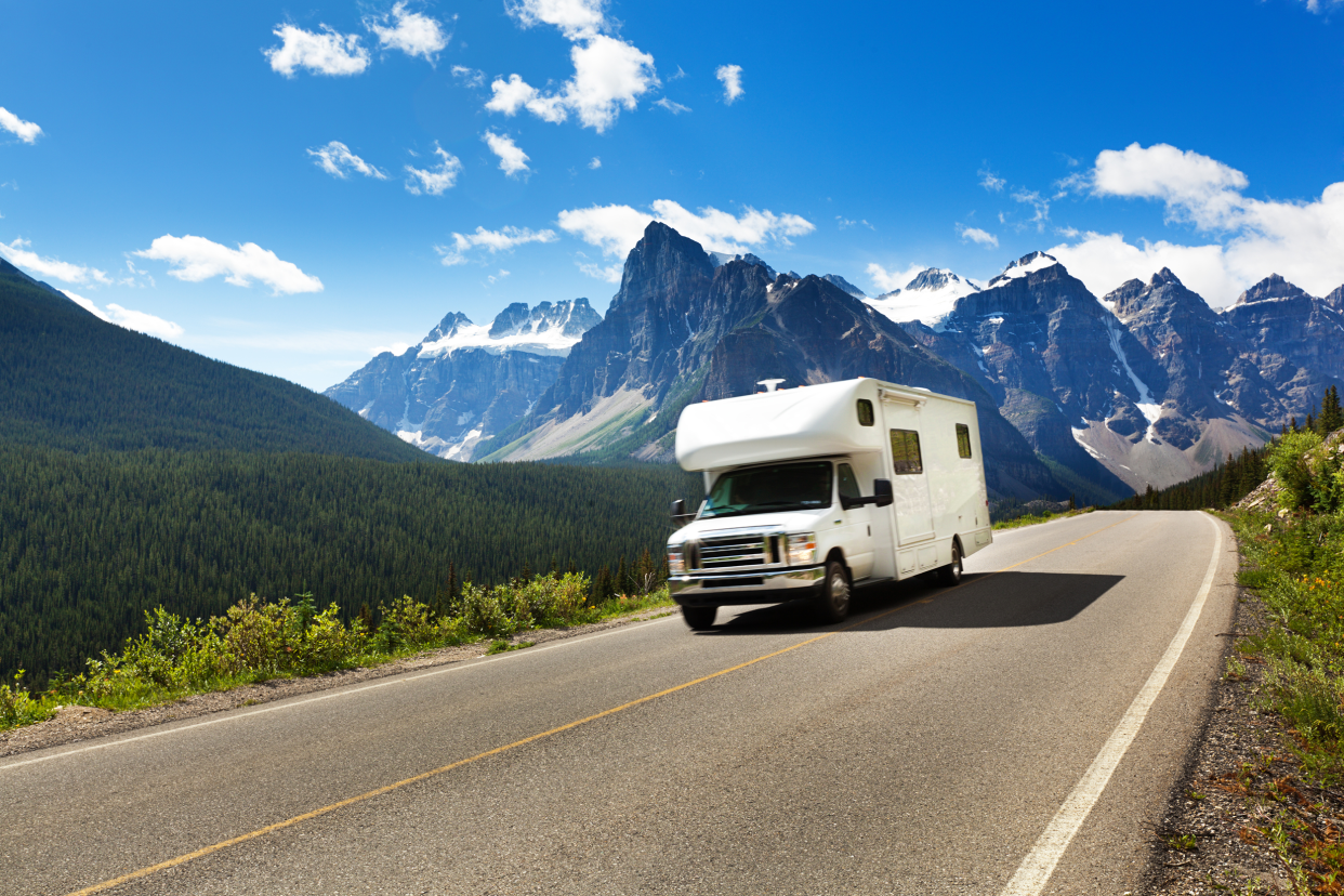 RV on the open road with mountains in the background
