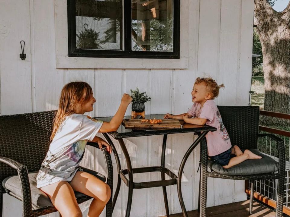 Katy's two daughters, Carolina and Harper, sitting on the porch.