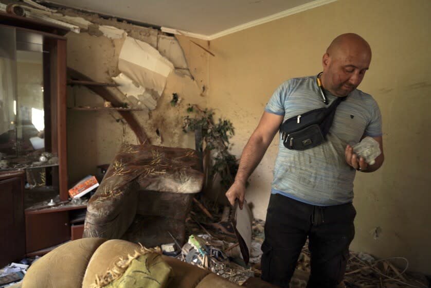 Denis Alyoshyn seeks to salvage whatever he can from his family's bombed out apartment in Borodyanka