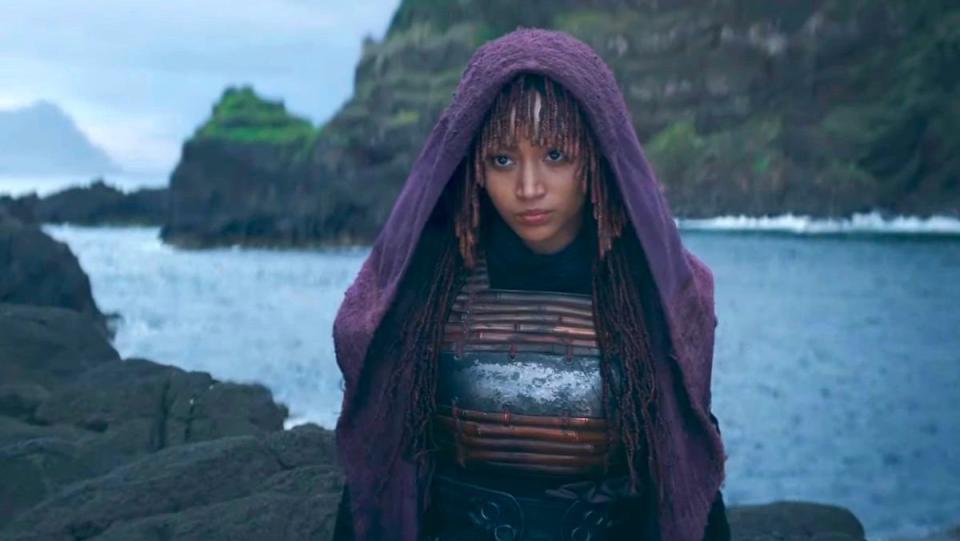 A woman in a purple robe stands near water in The Acolyte trailer still, The Acolyte is a new Star Wars series.