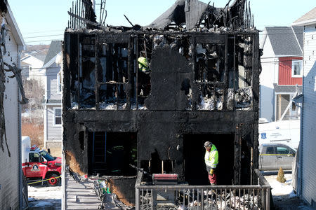 Fire investigators are seen at the house where seven children died from a fatal structure fire in the community of Spryfield in Halifax, Nova Scotia, Canada, on February 20, 2019. REUTERS/Ted Pritchard