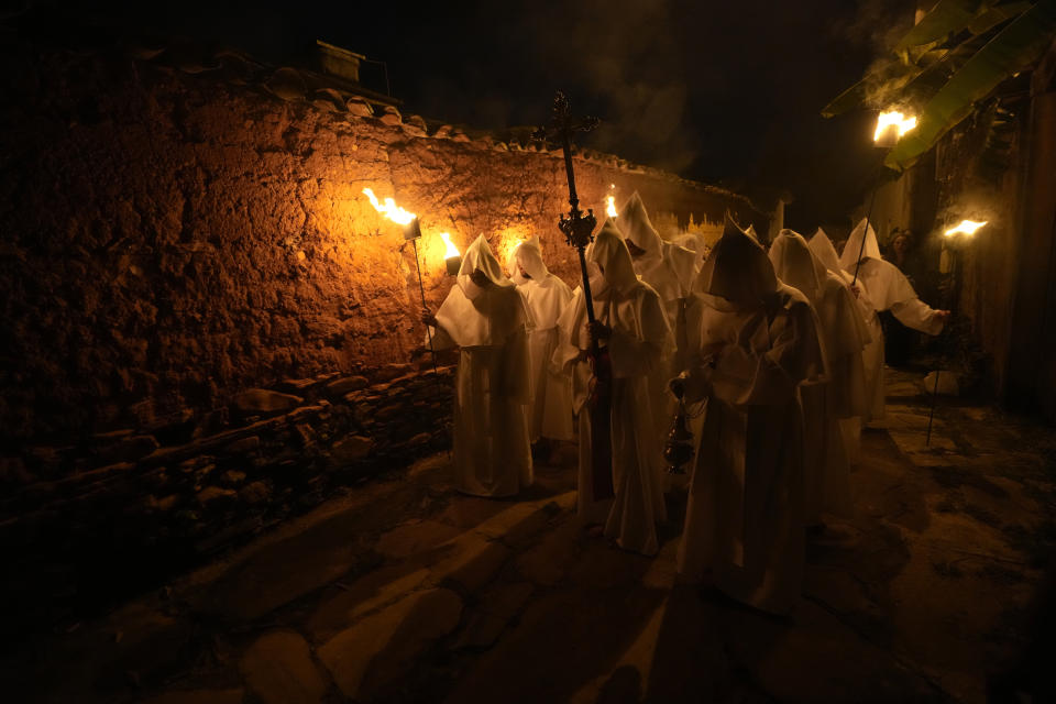 Penitents with tunics and hoods take part in the Procession of Souls in a Holy Week celebration in Goias, 350 km (217 miles) west of Brasilia, Brazil, Thursday, April 6, 2023. Penitents pray for souls, asking for the removal of the dead from purgatory. (AP Photo/Eraldo Peres)