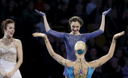 Figure Skating - ISU World Figure Skating Championships - Ladies Free Skate program - Boston, Massachusetts, United States - 02/04/16 - Silver medalist Ashley Wagner of the United States (L) watches as gold medalist Evgenia Medvedeva of Russia (top R) and bronze medalist Anna Pogorilaya of Russia greet each other at the awards podium. - REUTERS/Brian Snyder