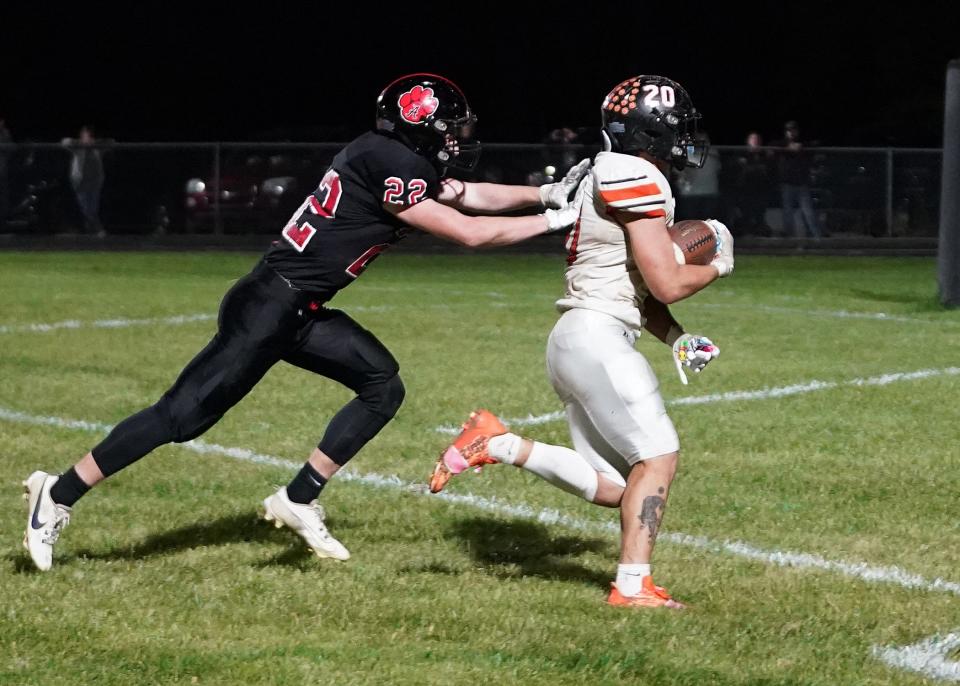 Hudson's Logan Ryan runs in for a touchdown after a reception while Addison's Spencer Brown reaches for him during Friday's Division 8 district game.