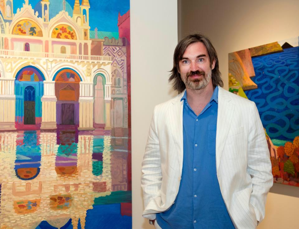 Daniel Heidkamp stands between two of his paintings, "San Marco" and "Positano Swirl."