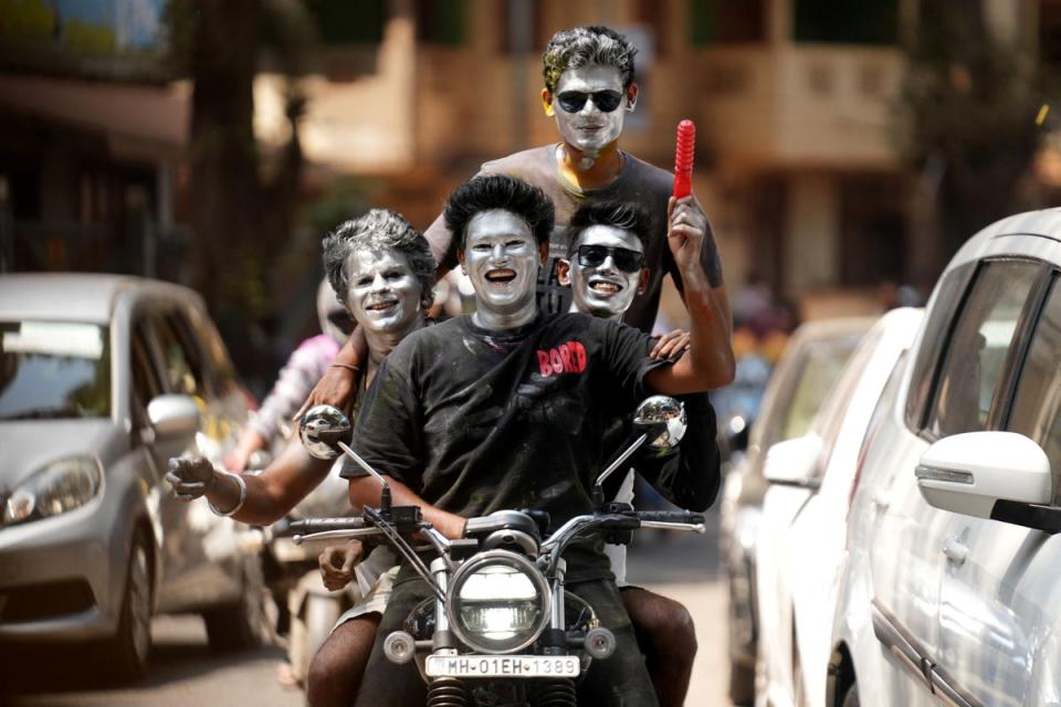 Boys with their faces painted in silver ride a motorbike during Holi celebrations in Mumbai (REUTERS)