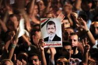 FILE PHOTO: A picture of Egypt's first Islamist President Mohamed Mursi is held up as supporters cheer during a rally at Tahrir Square in Cairo