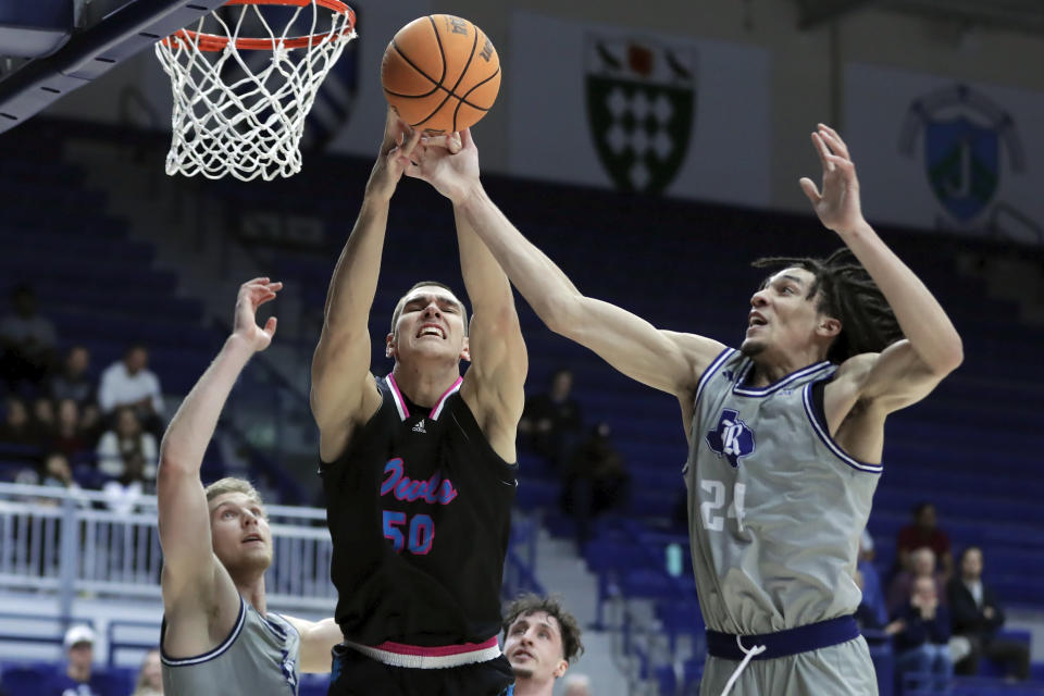 Florida Atlantic center Vladislav Goldin (50) battles for a rebound between Rice forward Max Fiedler, left, and Rice guard Gabe Warren, right, during the first half of an NCAA college basketball game Wednesday, Jan. 24, 2024, in Houston. (AP Photo/Michael Wyke)