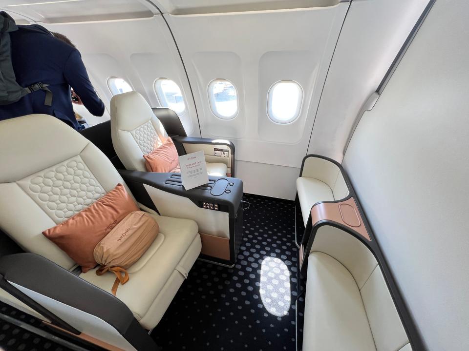 Two seats at the front of Beond's A319 in a cream leather, with foot stools