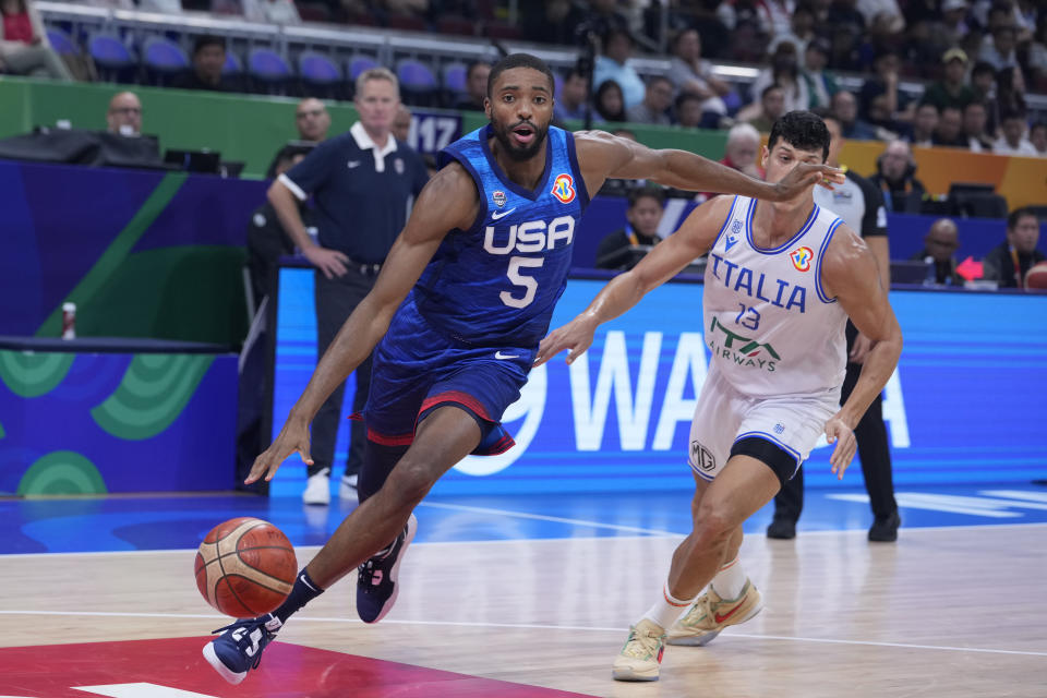 U.S. forward Mikal Bridges (5) drives past Italy forward Simone Fontecchio (13) during the Basketball World Cup quarterfinal game between Italy and U.S. at the Mall of Asia Arena in Manila, Philippines, Tuesday Sept. 5, 2023. (AP Photo/Michael Conroy)