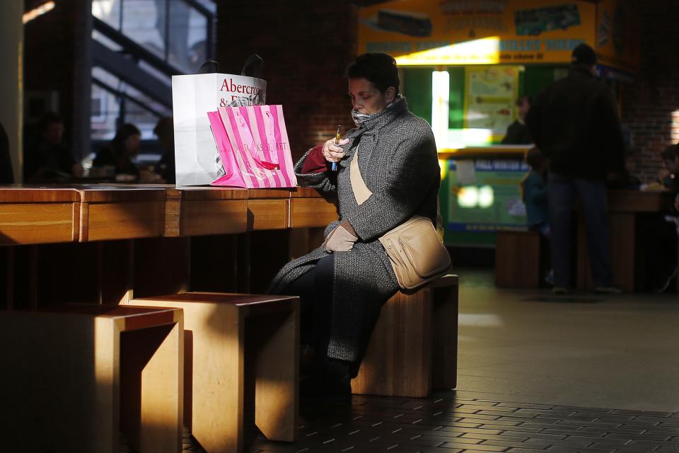 A shopper sits with her purchases at Faneuil Hall Marketplace in Boston