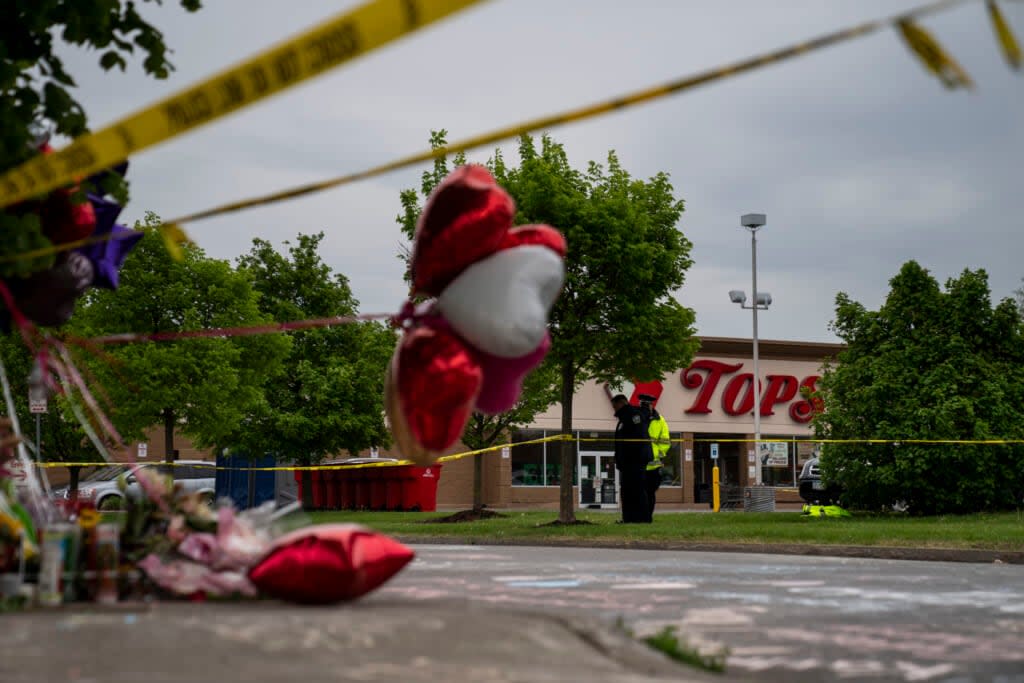 People gather at the scene of a mass shooting at Tops Friendly Market at Jefferson Avenue and Riley Street on Monday, May 16, 2022 in Buffalo, NY. (Kent Nishimura / Los Angeles Times via Getty Images)