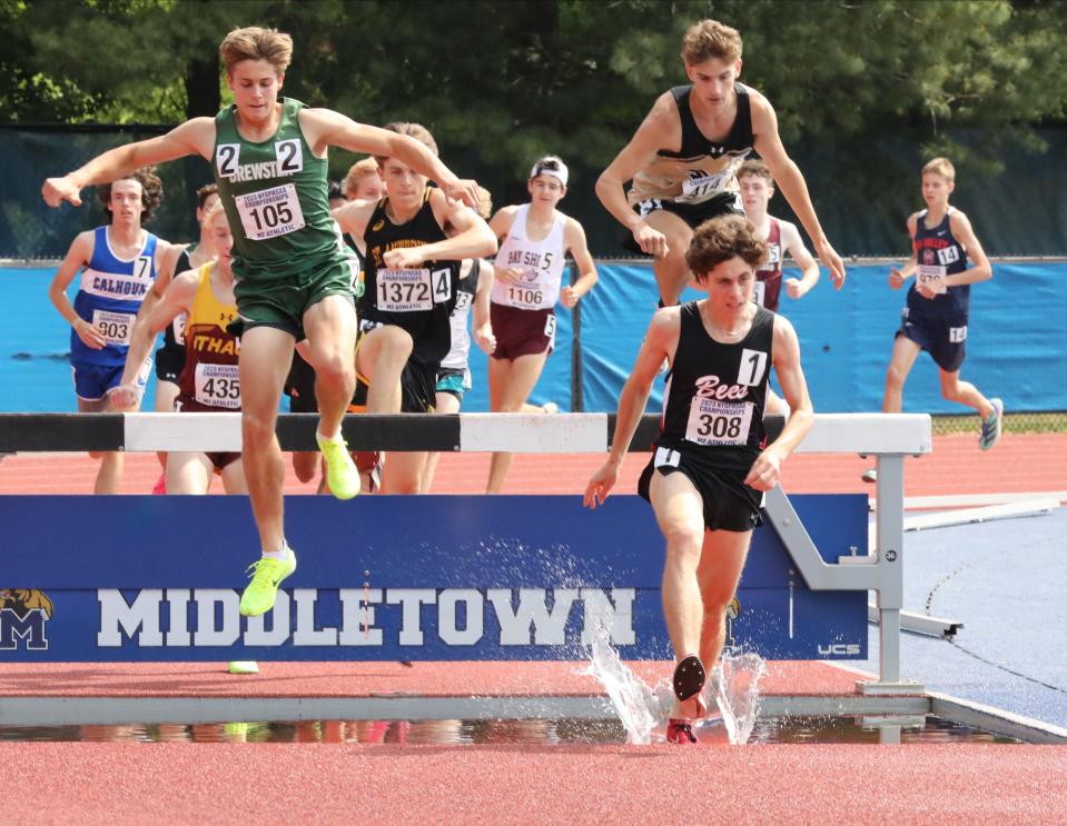 Athletes including Patrick Ford from Brewster (105) and Solomon Holden-Betts from Baldwinsville (308) compete in the boys 3000 meter steeplechase championship during the New York State Track and Field Championships at Middletown High School, June 10, 2023.