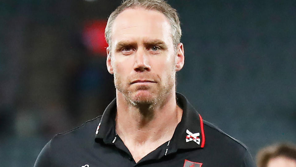 Bombers coach Ben Rutten walks off the field after an AFL match.