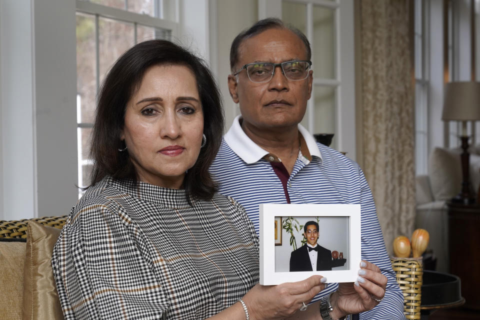 Vinita Rampuria, left, and her husband Ashoke Rampuria, of Acton, Mass., display a photograph of their son, Tuesday, April 4, 2023, at their home in Acton. The couple, whose son has struggled with mental illness and has been in and out of mental health care facilities for more than a decade, are supporting efforts in Massachusetts to create a new law that would let judges order the severely mentally ill into mandatory outpatient care after being released from a mental health institution. Massachusetts is one of only three states that don't give the courts that authority. (AP Photo/Steven Senne)