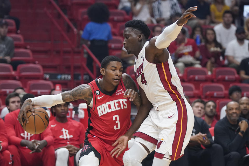 Houston Rockets guard Kevin Porter Jr. (3) drives up against Miami Heat guard Victor Oladipo (4) during the first half of a preseason NBA basketball game, Monday, Oct. 10, 2022, in Miami. (AP Photo/Wilfredo Lee)