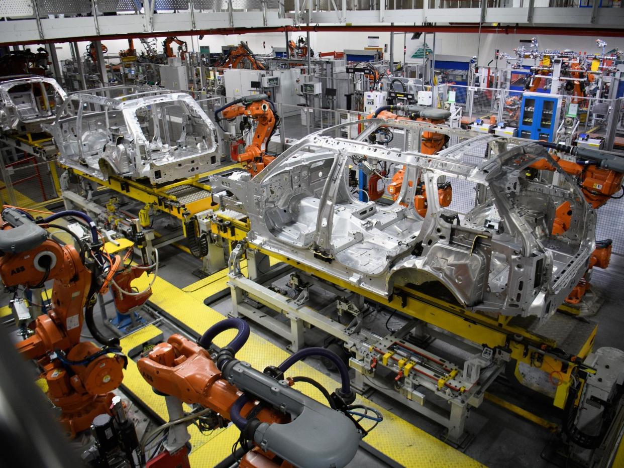 Robotic systems work on the chassis of a car during an automated stage of production at the Jaguar Land Rover factory: Getty