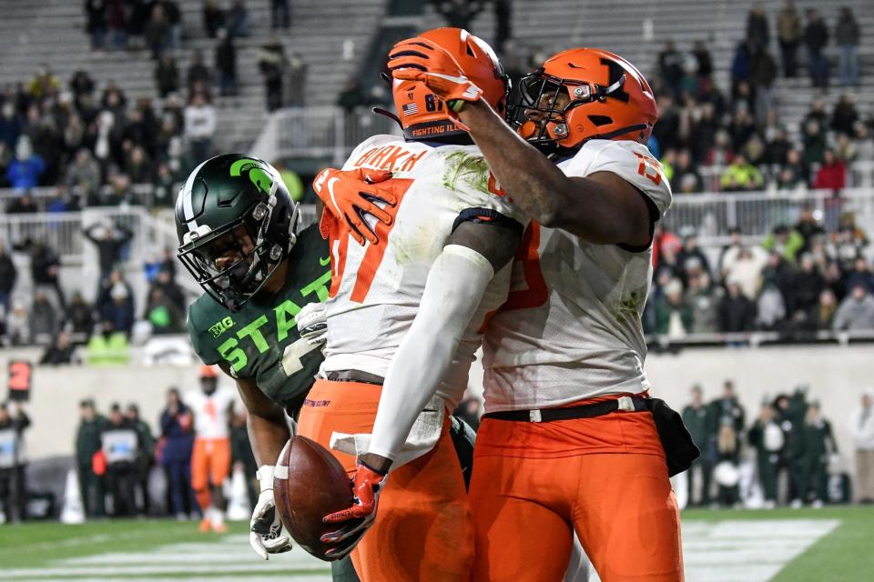 Illinois' Daniel Barker, left, celebrates his game-winning touchdown with teammate Caleb Reams late during the fourth quarter on Saturday, Nov. 9, 2019, at Spartan Stadium in East Lansing.