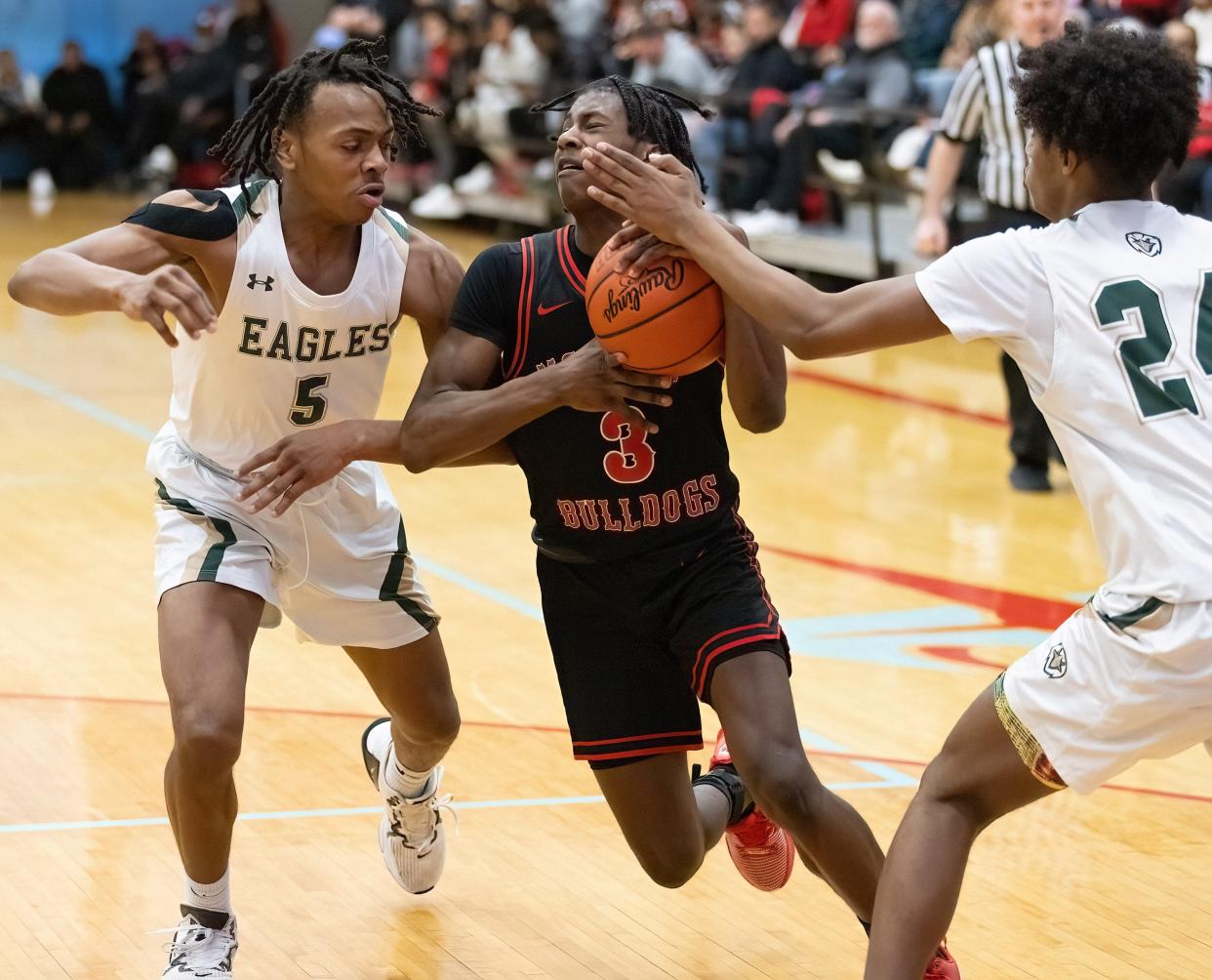 McKinley’s Jaylen Jeter drives between GlenOak’s Katour Ashcraft (5) and Issa White (24) during a district semifinal, Thursday, March 7, 2024.