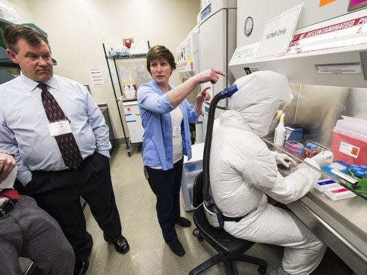 Darren Berger and Kelly Moore describe the personal protective equipment worn by a researcher at the Influenza Research Institute at the University of Wisconsin-Madison in 2014. During the tour, the high-security research facility was closed down for annual decontamination, cleaning and maintenance.