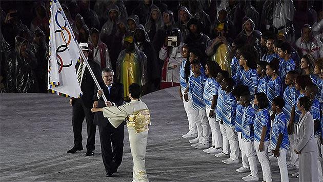 International Olympic Committee (IOC) President Thomas Bach (C) hands the Olympic flag to the Governor of Tokyo Yuriko Koike. Pic: AFP