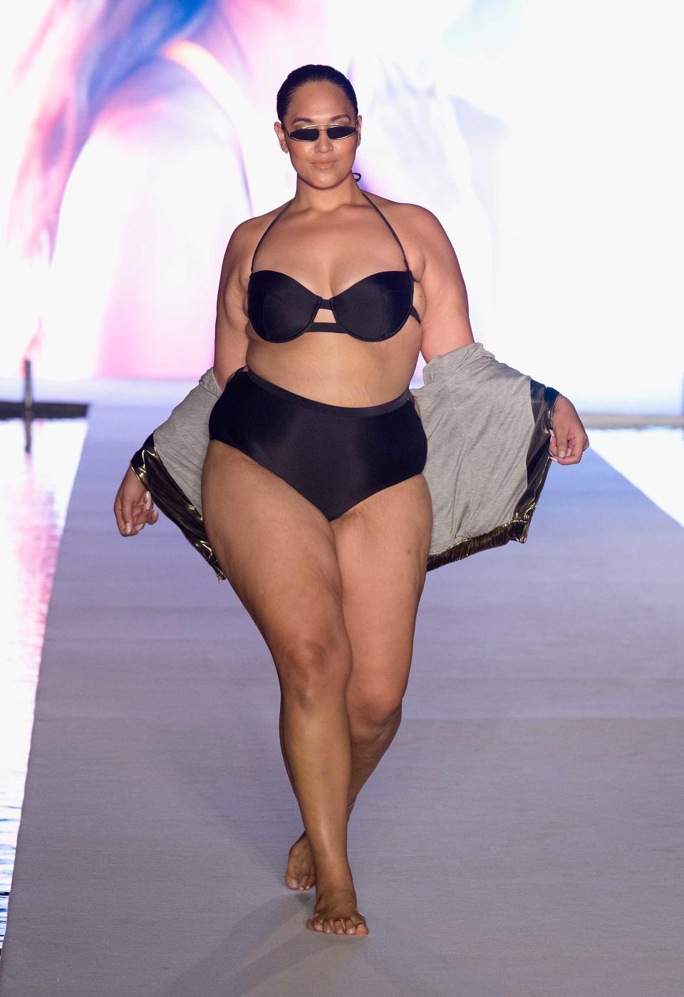 <p>A model walks the runway wearing trendy tiny sunglasses and a black bikini set for the swimsuit show during the Paraiso Fashion Fair in Miami at the W South Beach hotel on July 15. (Photo: Alexander Tamargo/Getty Images for Sports Illustrated) </p>