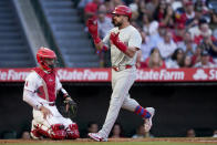 Philadelphia Phillies designated hitter Kyle Schwarber celebrates while crossing home plate next to Los Angeles Angels catcher Logan O'Hoppe after hitting a three-run home run to score Nick Castellanos and Bryson Stott during the second inning of a baseball game, Tuesday, April 30, 2024, in Anaheim, Calif. (AP Photo/Ryan Sun)