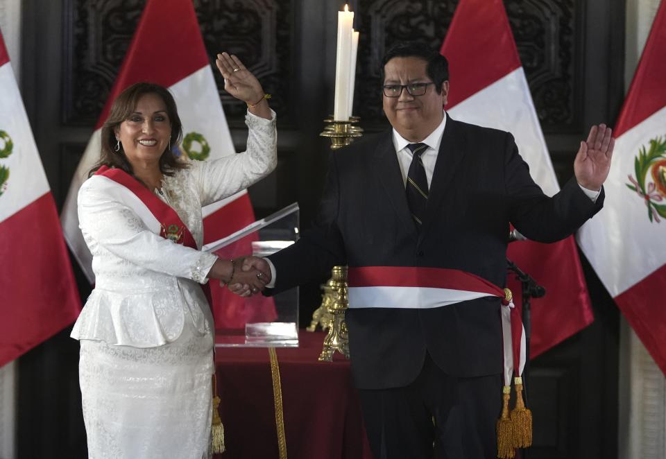 Peru's President Dina Boluarte and her newly named Economy Minister Alex Contreras wave during a swearing-in ceremony for her cabinet members, at the government palace in Lima, Peru, Saturday, Dec. 10, 2022. (AP Photo/Guadalupe Pardo)