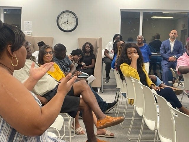 An employee of the Evans Center asks questions during a community forum on the closure of the center. She, like others at Evans, will lose her job when the center closes on Aug. 31.