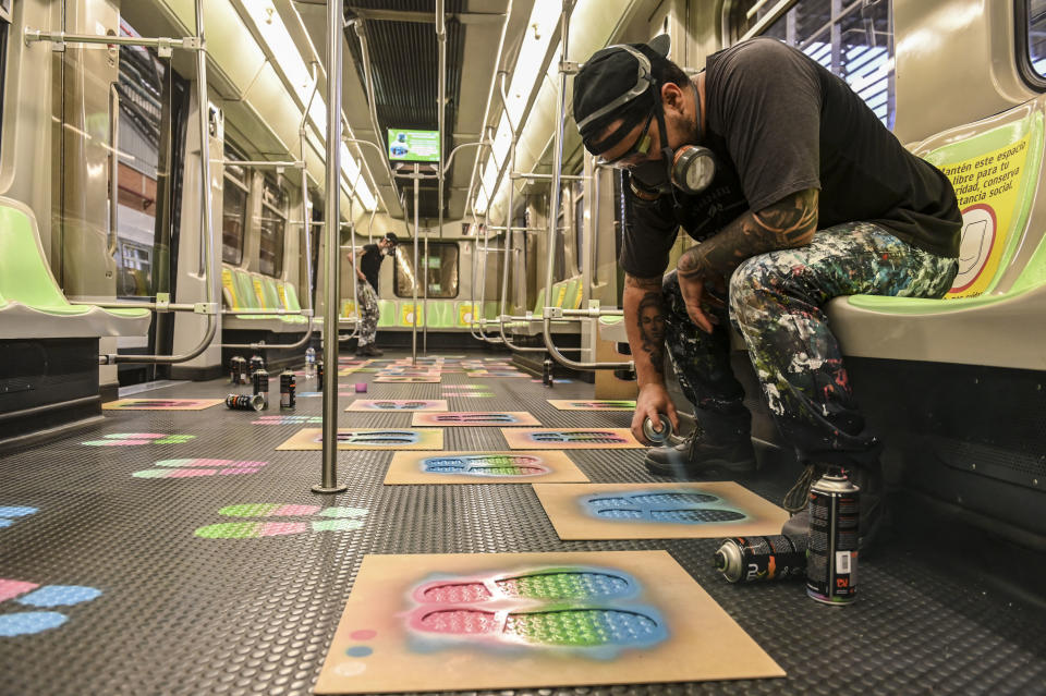 Graffiti artists paint special marks on a metro car in Medellín, Colombia.