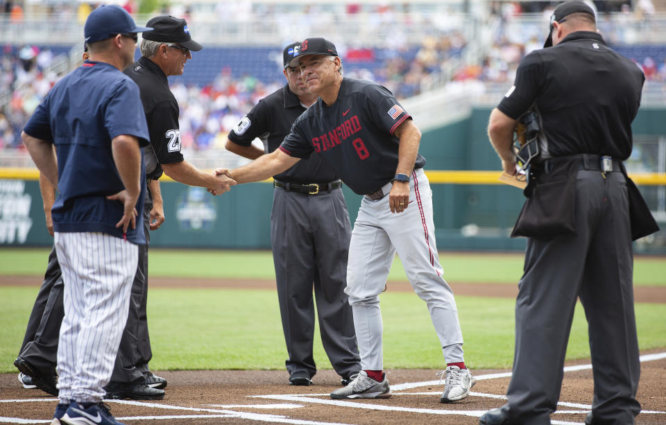 FILE - Stanford head coach David Esquer, center right, shakes hands with an umpire while meeting with Arizona head coach Jay Johnson before their baseball game in the College World Series Monday, June 21, 2021, at TD Ameritrade Park in Omaha, Neb. The inaugural Pac-12 NCAA college baseball tournament will take place in Scottsdale, Ariz., May 25-29, 2022. (AP Photo/Rebecca S. Gratz, File)