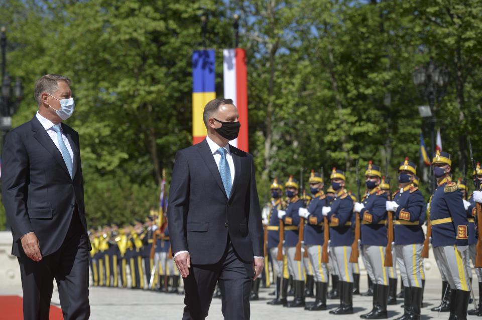 Polish President Andrzej Duda, right, reviews the honor guard with Romanian President Klaus Iohannis during the welcoming ceremony at the Cotroceni presidential palace in Bucharest, Romania, Monday, May 10, 2021. (AP Photo/Alexandru Dobre)