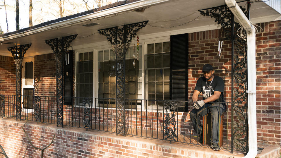 Prince Beatty takes a seat on a broken speaker outside on the front porch of his home in East Point, Ga. Beatty, a 47-year-old Navy veteran, faces eviction this month for unpaid rent despite his landlord getting more than $20,000 in federal rental assistance. (AP Photo/Hakim Wright Sr.)