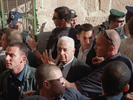 An Israeli security guard holds his hand over the face of then-opposition leader Ariel Sharon to protect him from rocks being thrown by Palestinians during his visit to the compound known to Muslims as Noble Sanctuary and to Jews as Temple Mount in this September 28, 2000 file photo. REUTERS/Stringer/Files