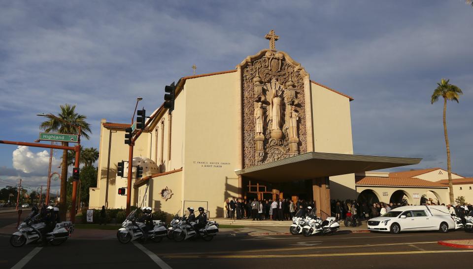 The hearse carrying the casket of former Democratic U.S. Rep. Ed Pastor prepares to leave St. Francis Xavier Catholic Church after his funeral Friday, Dec. 7, 2018, in Phoenix. Pastor was Arizona's first Hispanic member of Congress, spending 23 years in Congress before retiring in 2014. Pastor passed away last week at the age of 75. (AP Photo/Ross D. Franklin)