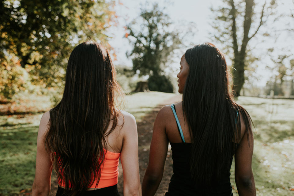 Two individuals outdoors in workout attire, seen from behind, looking ahead