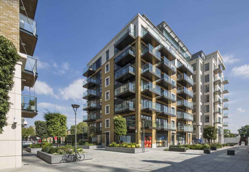 Sunlit corner elevation within pedestrianized zone and context. Fulham Reach Luxury Apartments, London, United Kingdom. Architect: John Thompson and Partners LLP, 2015. (Photo by: Anthony Weller/View Pictures/Universal Images Group via Getty Images)