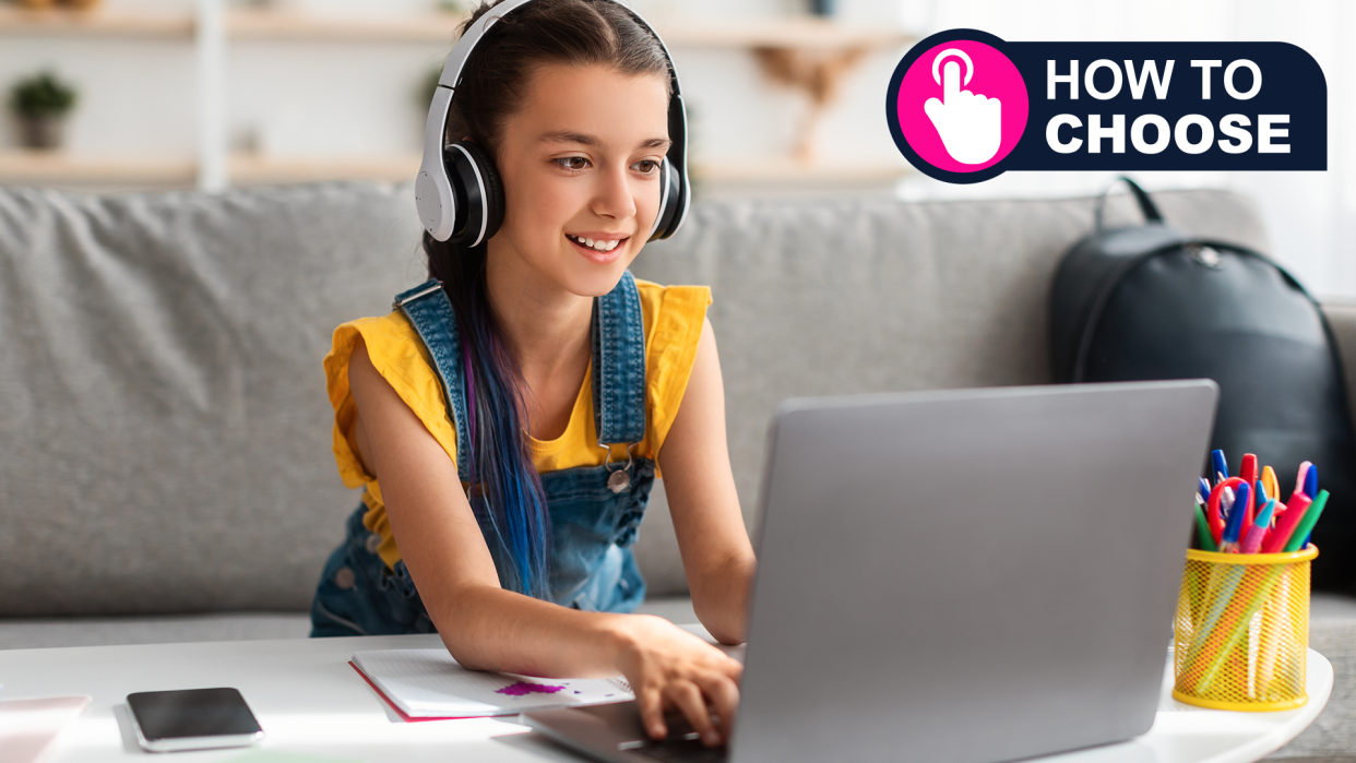  Portrait of little girl in wireless headset using laptop, studying online at home. 